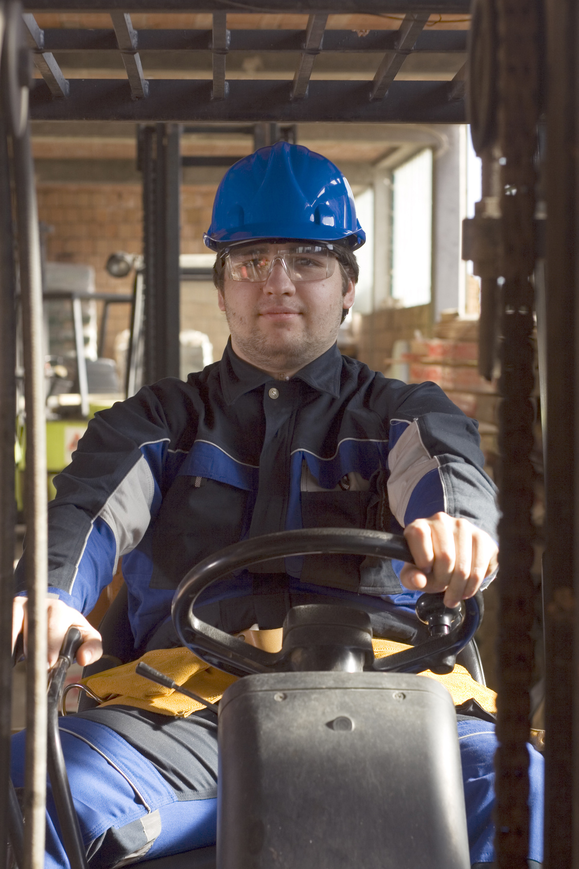 Construction worker in workplace driving forklift Construction worker in workplace driving forklift