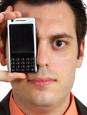 Man with a mobile phone held to his right eye